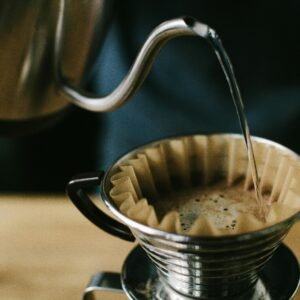 Close-up of a manual pour over coffee brewing process, highlighting the coffee and filter.