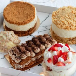 A tempting variety of gourmet cakes and pastries displayed in an elegant box, perfect for dessert lovers.